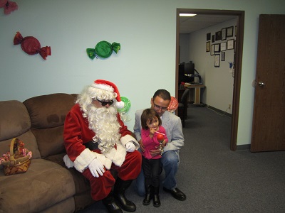 Santa posing with a Father and Daughter